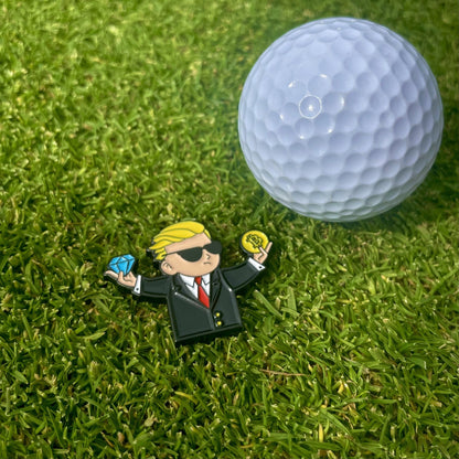 Ballmarker Diamond Hands von Alpha Putts neben einem Golfball auf dem Grün